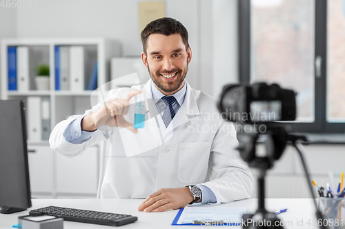 Image of doctor with hand sanitizer recording video blog