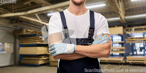 Image of close up of male builder in overall and gloves