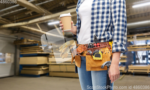 Image of woman with takeaway coffee cup and working tools