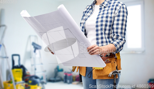 Image of female builder with blueprint and working tools