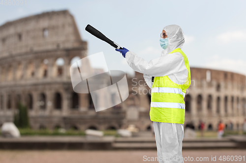 Image of sanitation worker in hazmat with pressure washer