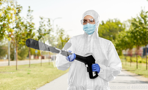 Image of sanitation worker in hazmat with pressure washer