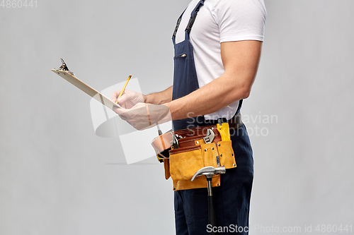 Image of builder with clipboard, pencil and working tools