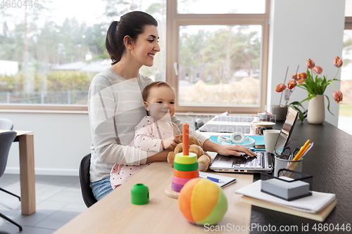 Image of mother with baby and laptop working at home office