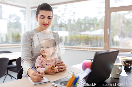 Image of mother with baby working at home office