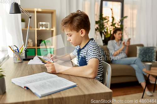 Image of student boy with tablet computer learning at home