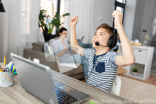 Image of boy with laptop and headphones at home