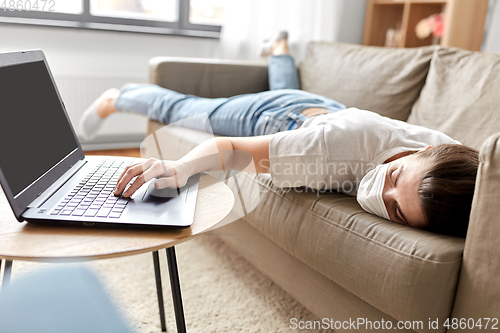 Image of sick bored woman with laptop lying on sofa at home