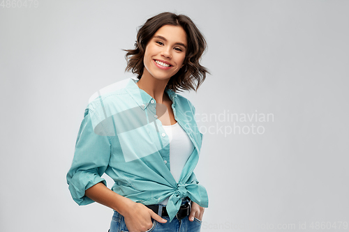 Image of portrait of smiling young woman in turquoise shirt