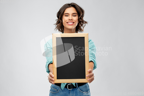 Image of portrait of smiling woman showing black chalkboard