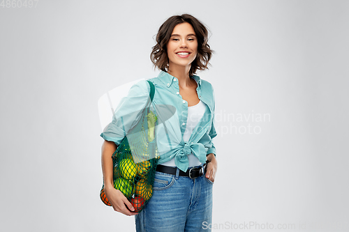 Image of happy smiling woman with food in reusable net bag