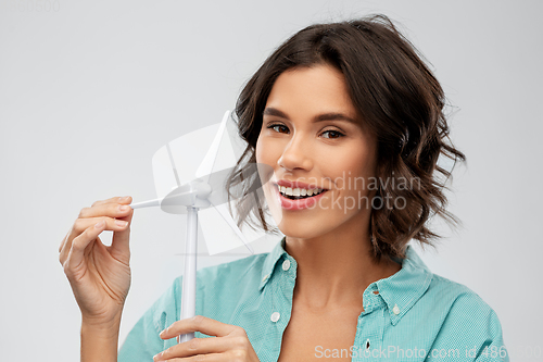 Image of happy smiling young woman with toy wind turbine