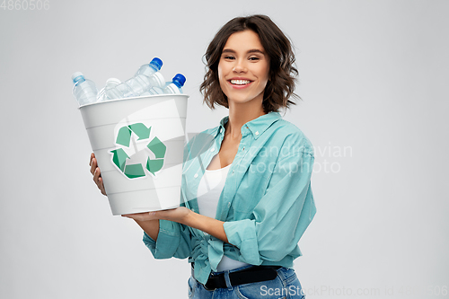 Image of smiling young woman sorting plastic waste