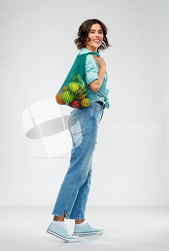 Image of happy smiling woman with food in reusable net bag