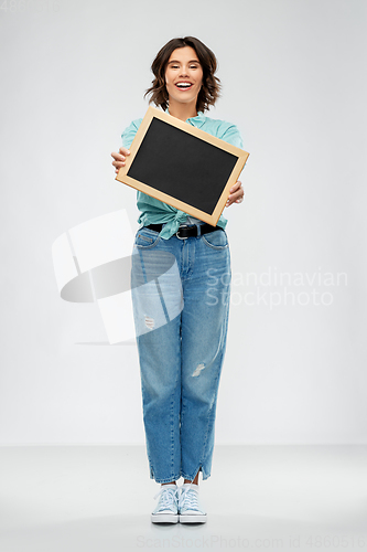 Image of portrait of smiling woman showing black chalkboard