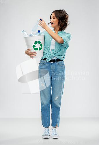 Image of smiling young woman sorting plastic waste