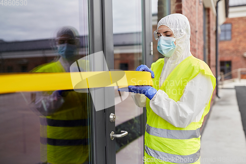 Image of healthcare worker sealing door with caution tape