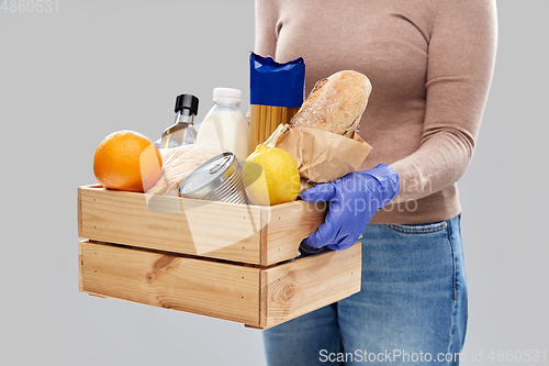 Image of woman in gloves with food in wooden box