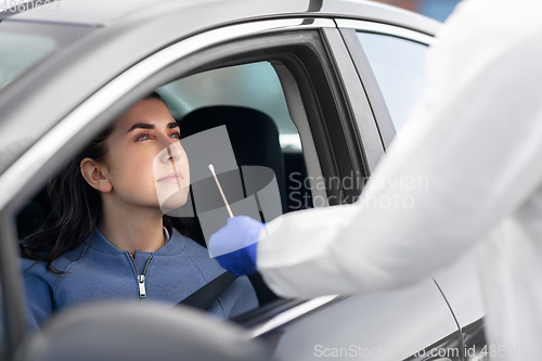 Image of healthcare worker making coronavirus test at car