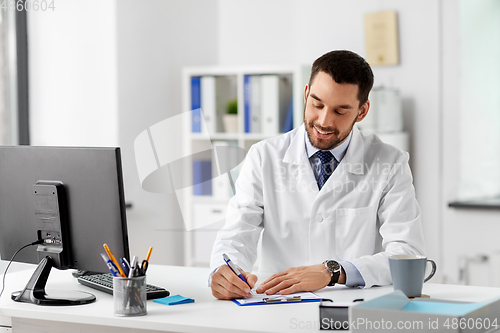 Image of smiling male doctor with clipboard at hospital