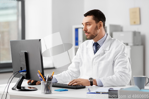 Image of male doctor with computer working at hospital