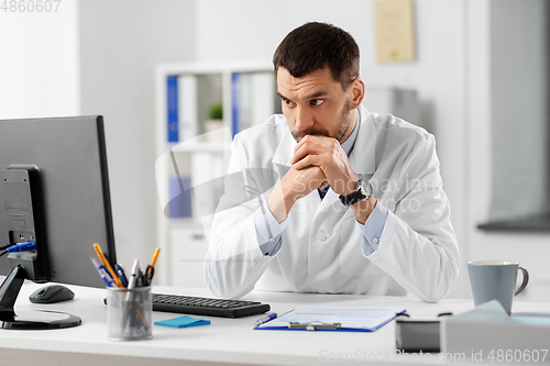 Image of doctor with clipboard and computer at hospital