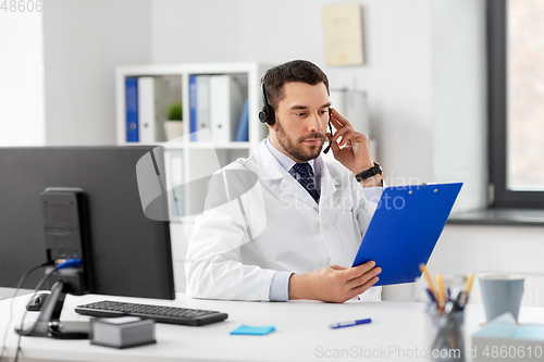 Image of male doctor with headset and clipboard at hospital