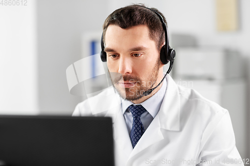 Image of male doctor with computer and headset at hospital