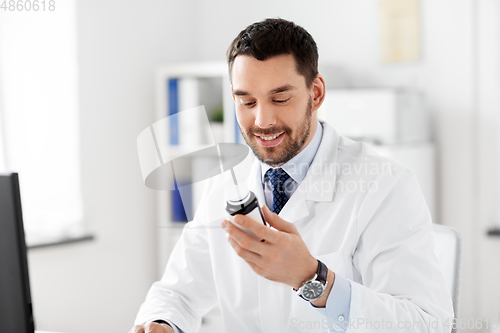 Image of smiling male doctor with medicine at hospital