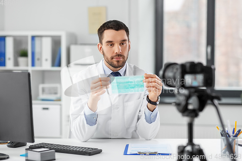 Image of doctor with mask recording video blog at hospital