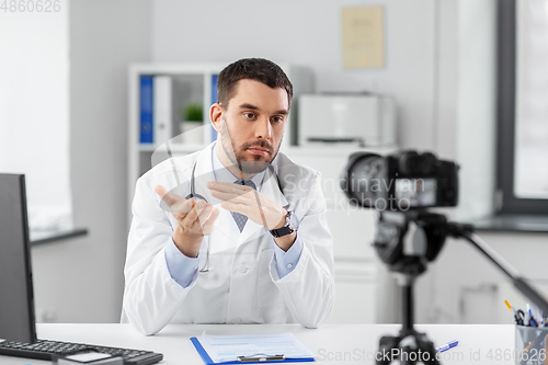 Image of male doctor recording video blog at hospital