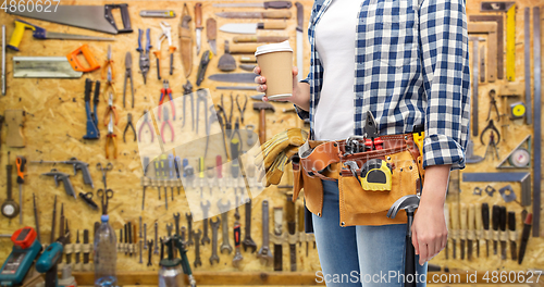 Image of woman with takeaway coffee cup and working tools