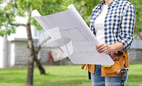 Image of female builder with blueprint and working tools