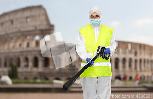 Image of sanitation worker in hazmat with pressure washer