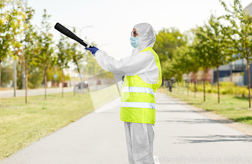 Image of sanitation worker in hazmat with pressure washer