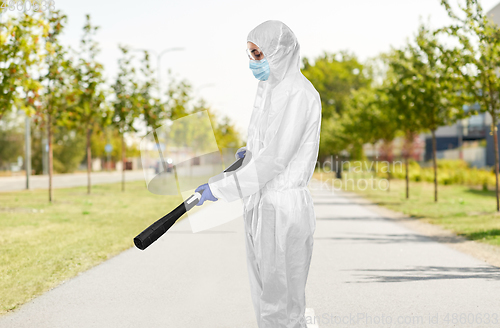 Image of sanitation worker in hazmat with pressure washer