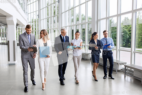 Image of business people walking along office building