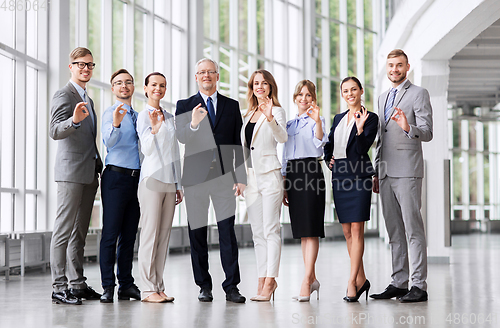Image of business people showing ok hand sign at office