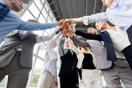 Image of business people making high five at office