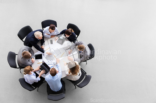 Image of architects with laptop and blueprint at office