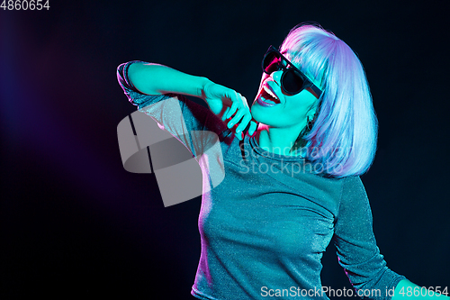 Image of happy woman in pink wig and sunglasses dancing