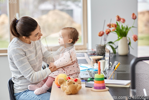 Image of mother with baby working at home office