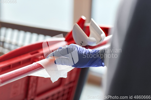 Image of hand cleaning shopping cart handle with wet wipe