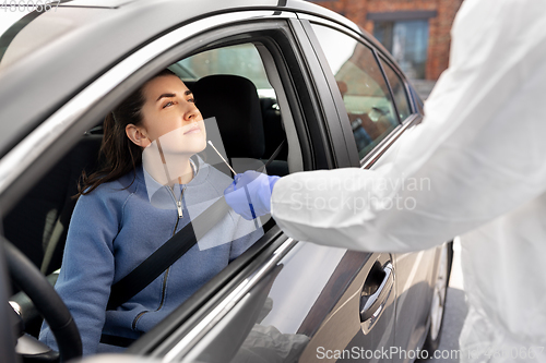 Image of healthcare worker making coronavirus test at car