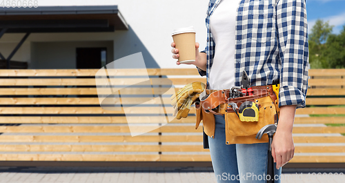 Image of woman with takeaway coffee cup and working tools