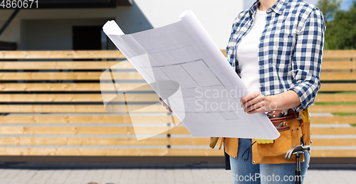Image of female builder with blueprint and working tools