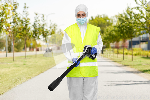 Image of sanitation worker in hazmat with pressure washer