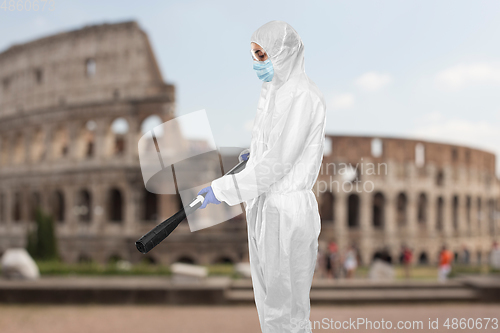 Image of sanitation worker in hazmat with pressure washer