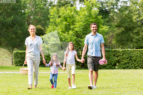 Image of family with picnic basket walking in summer park