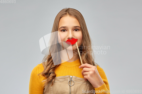 Image of happy teenage girl with red lips party accessory